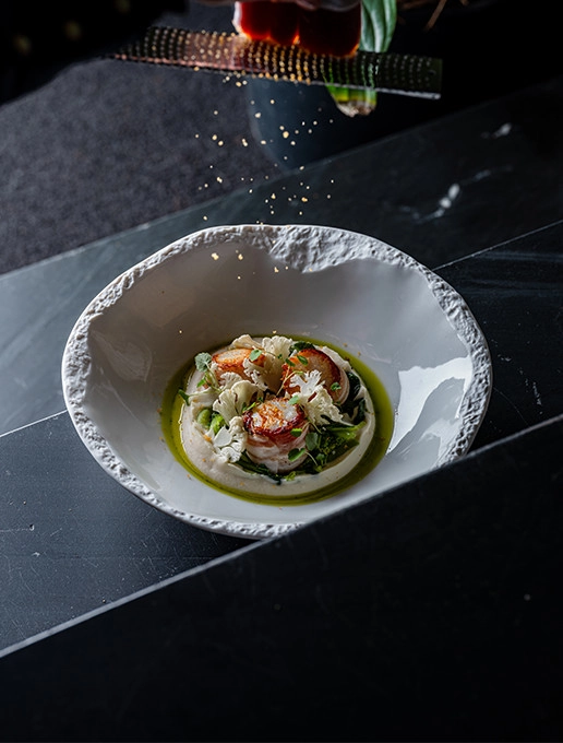 Refined dish of scallops with emulsion and crunchy vegetables served at Dans le Noir ? restaurant