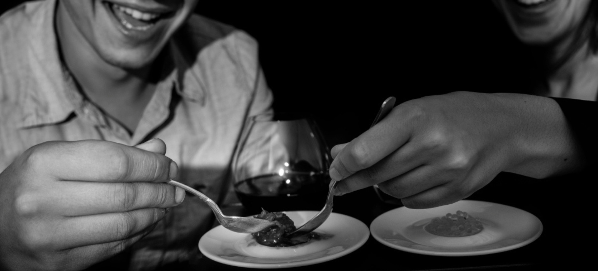 Moment of tasting and sharing in the dark at the Dans le Noir ? restaurant, highlighting a unique sensory gastronomic experience.